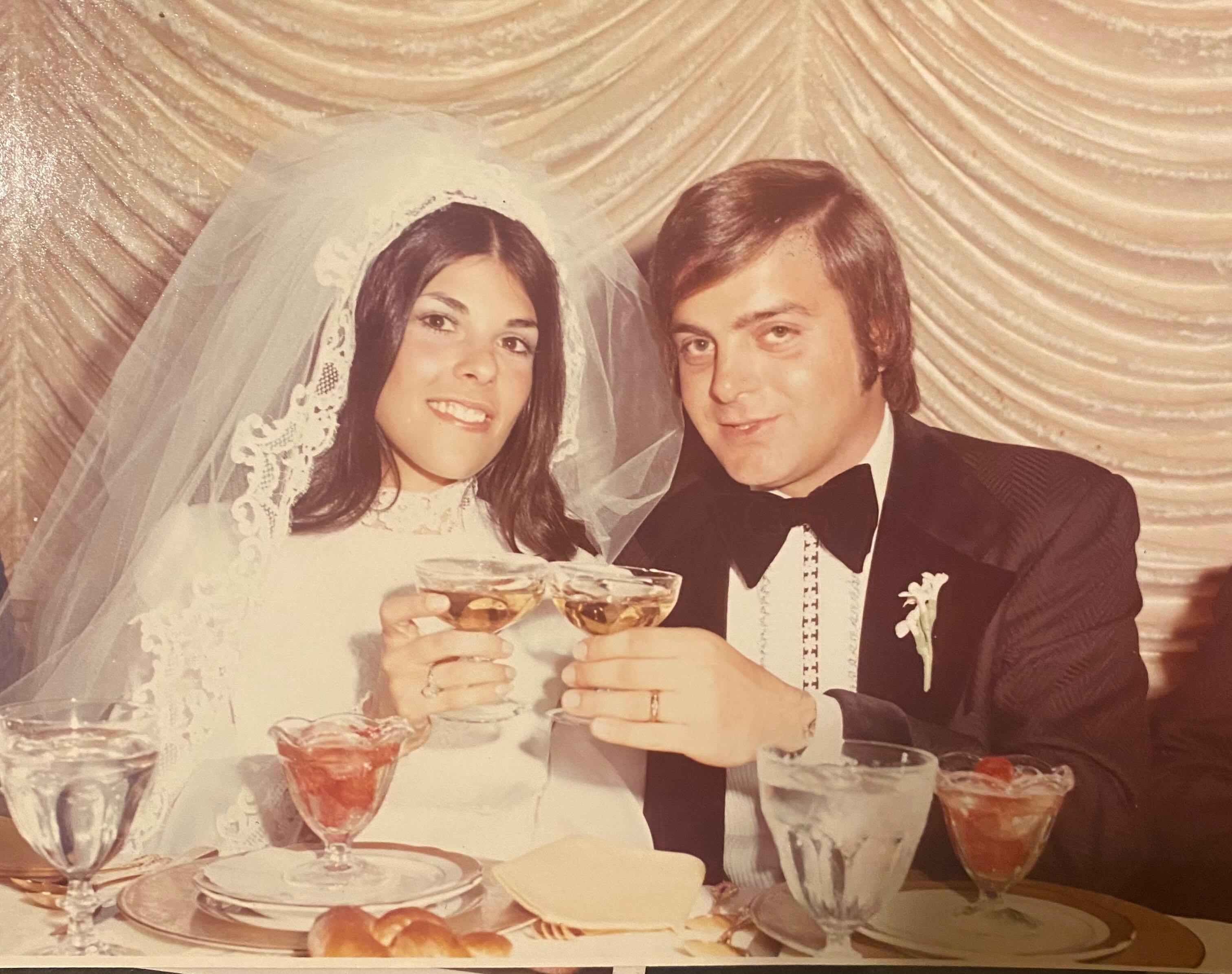 Lucy and John toasting at their wedding